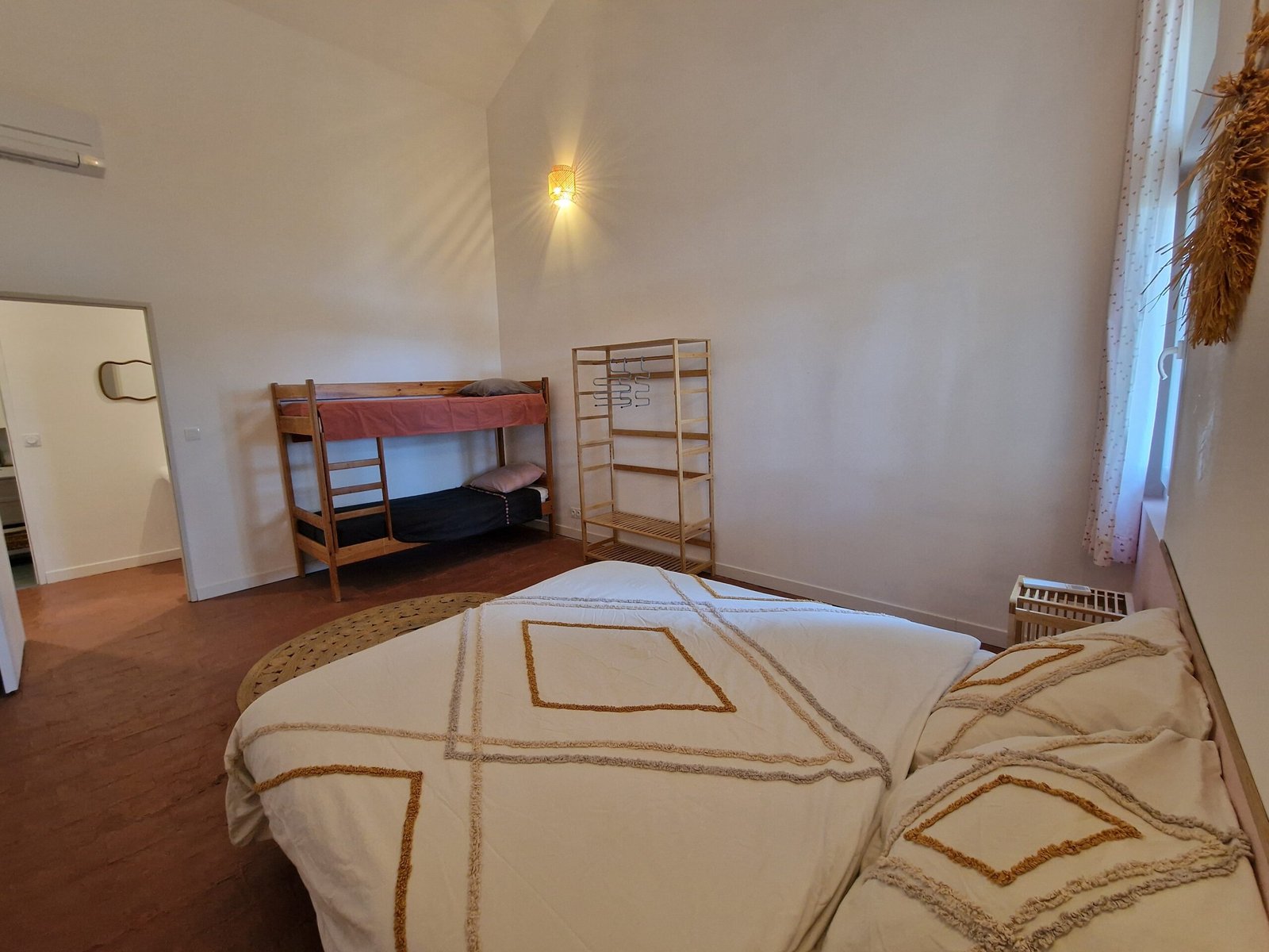Chambre familiale avec lit double et lits superposés dans un gîte de groupe à Narbonne