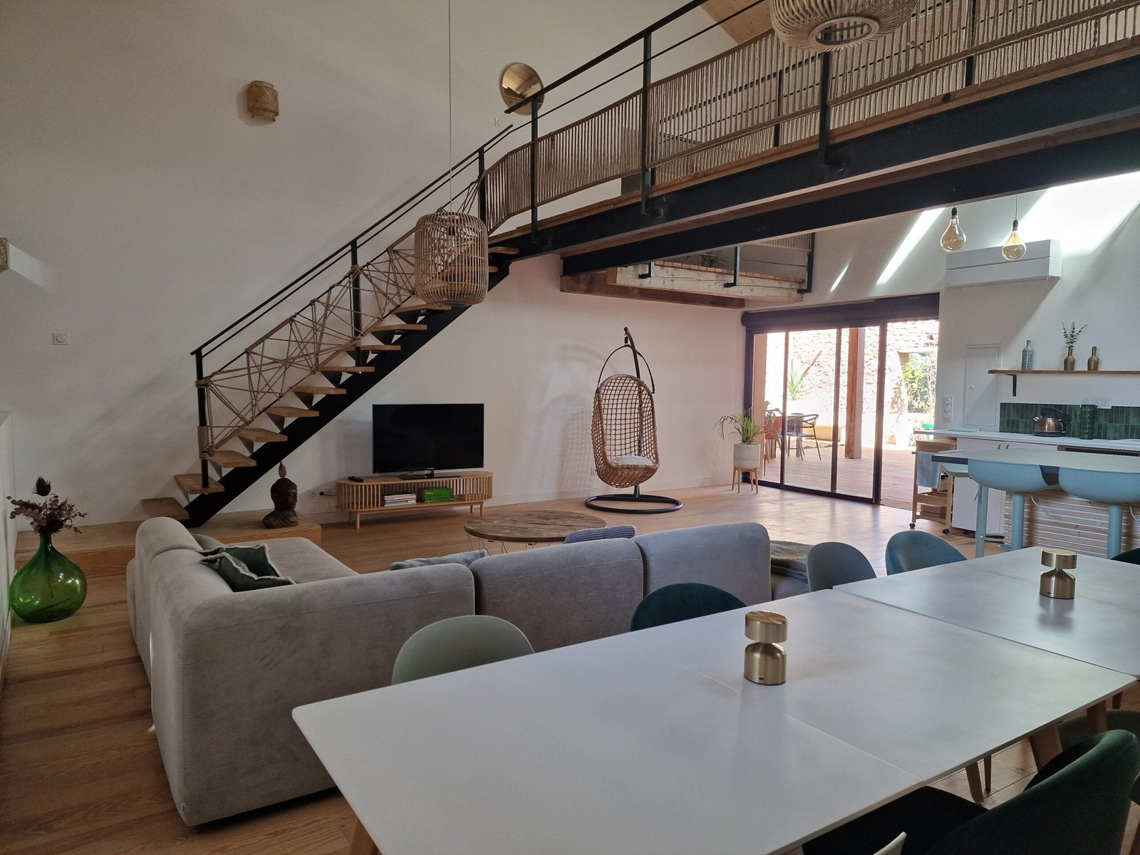 Grande pièce de vie avec salon, salle à manger, cuisine ouverte et mezzanine dans un gîte à Narbonne