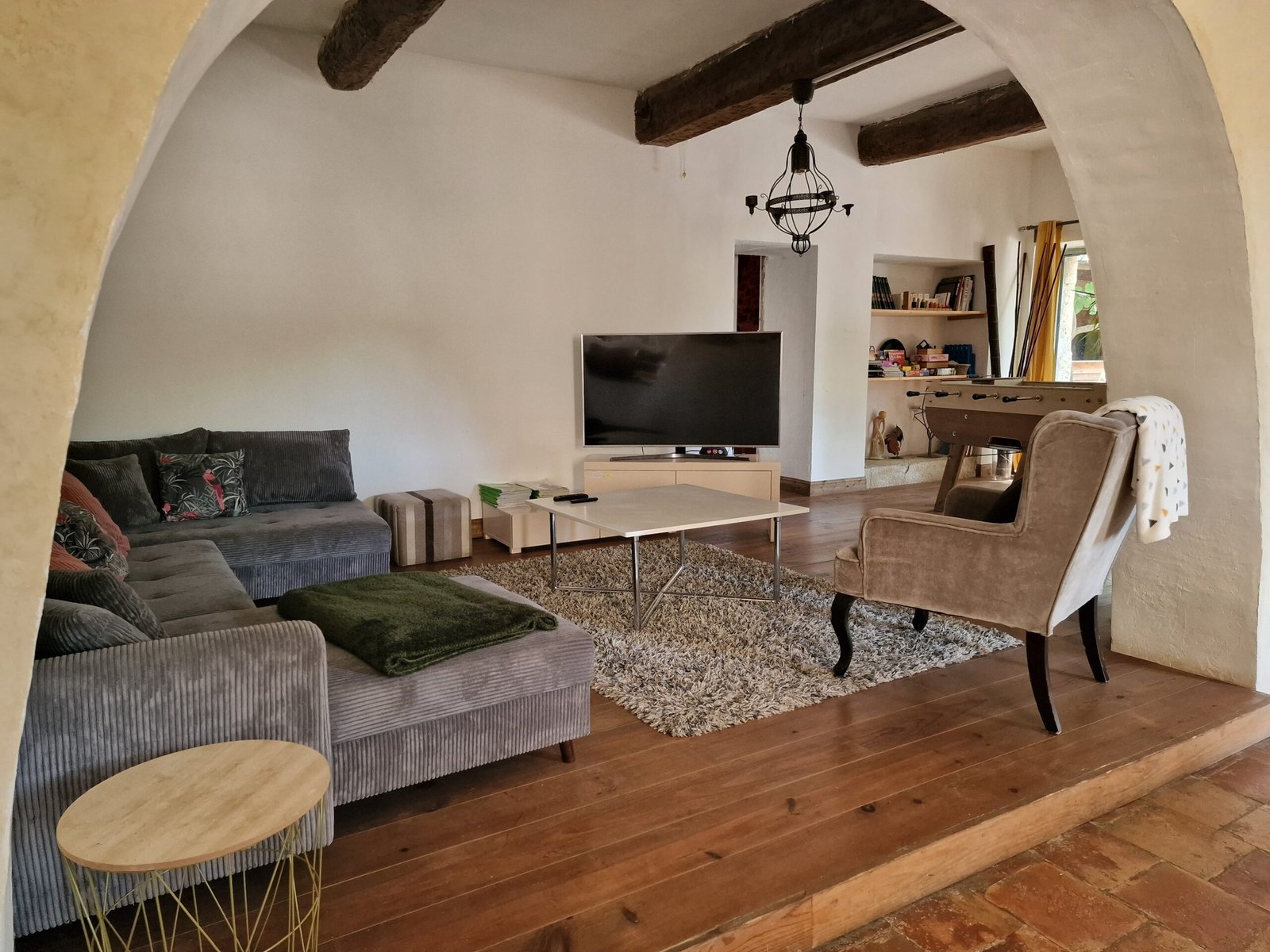 Salon avec télévision et baby-foot dans un gîte de groupe à Narbonne, aménagé pour les séjours entre amis ou en famille.