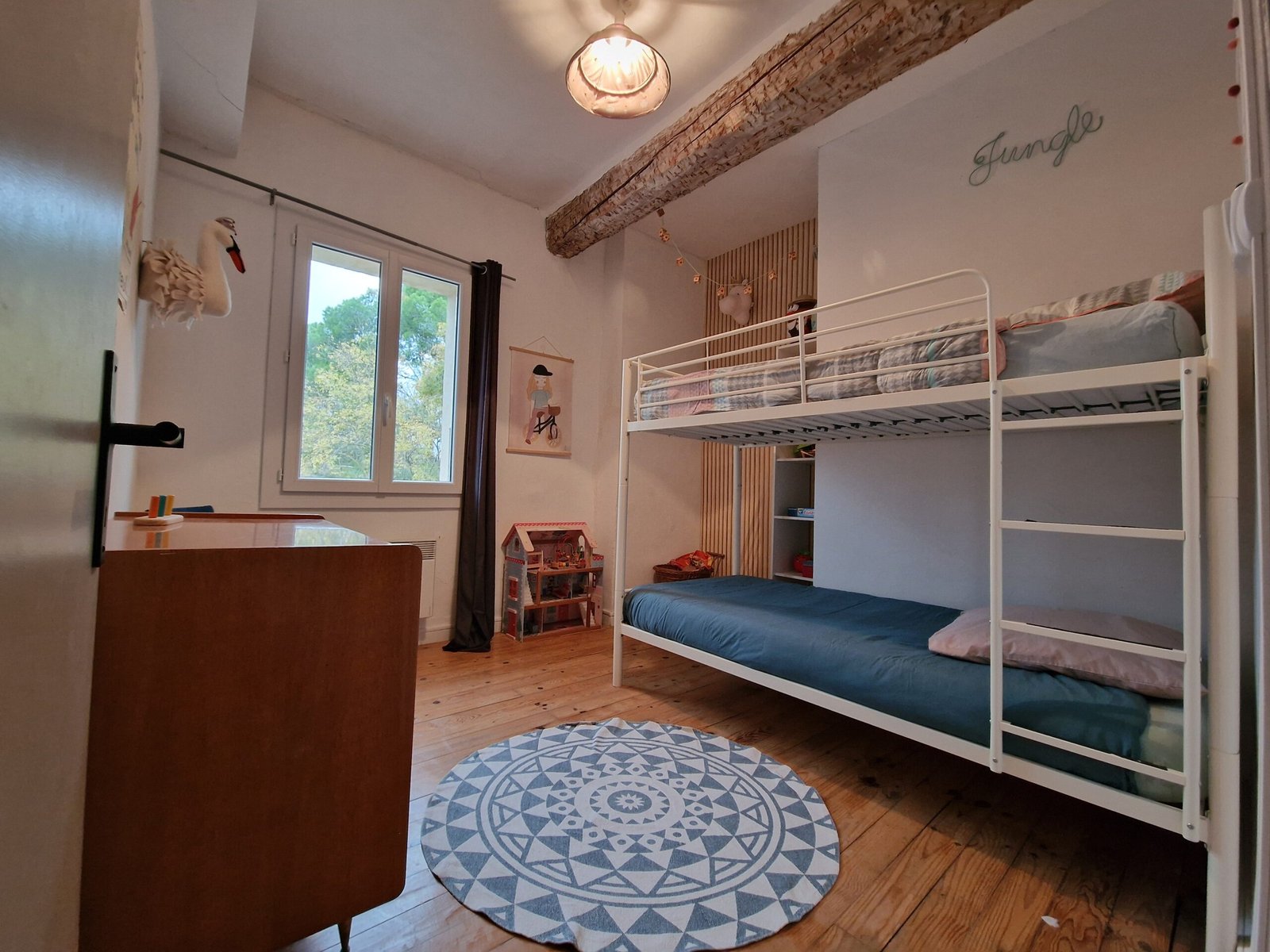 Chambre familiale du gîte à Narbonne avec lits superposés, espace de jeux et parquet en bois.