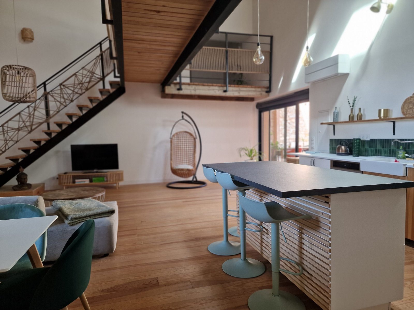 Cuisine ouverte avec grand îlot central donnant sur la pièce de vie d’un gîte à Narbonne