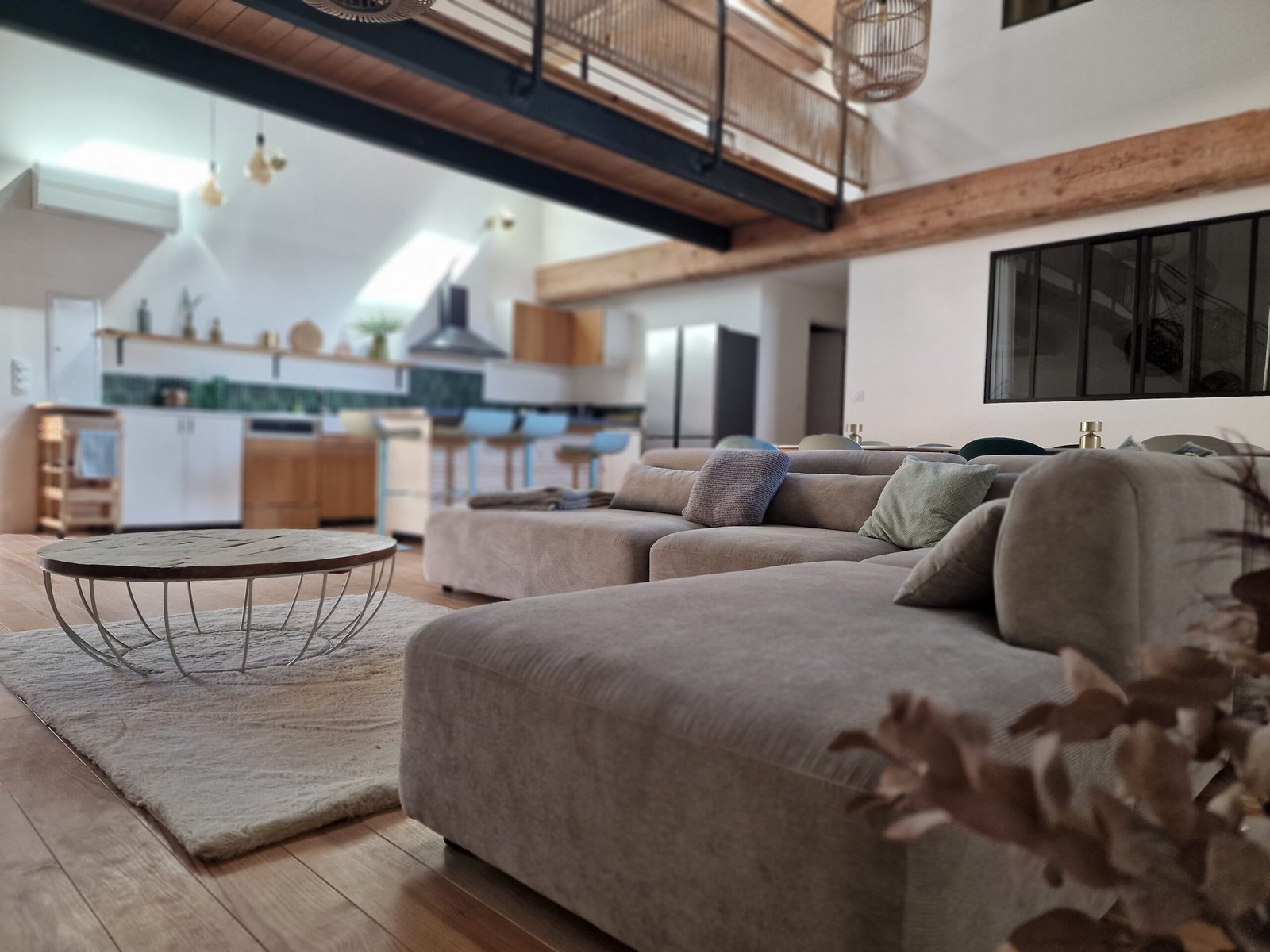 Grand salon avec canapé d’angle et cuisine ouverte dans un gîte de groupe à Narbonne