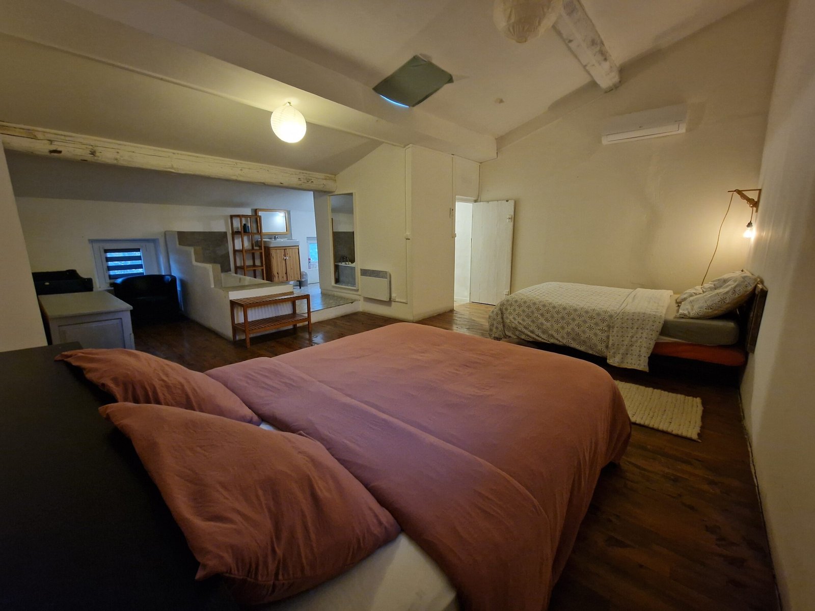 Grande chambre avec deux lits doubles dans un gîte à Narbonne, idéale pour accueillir plusieurs personnes lors d’un séjour en famille ou entre amis.