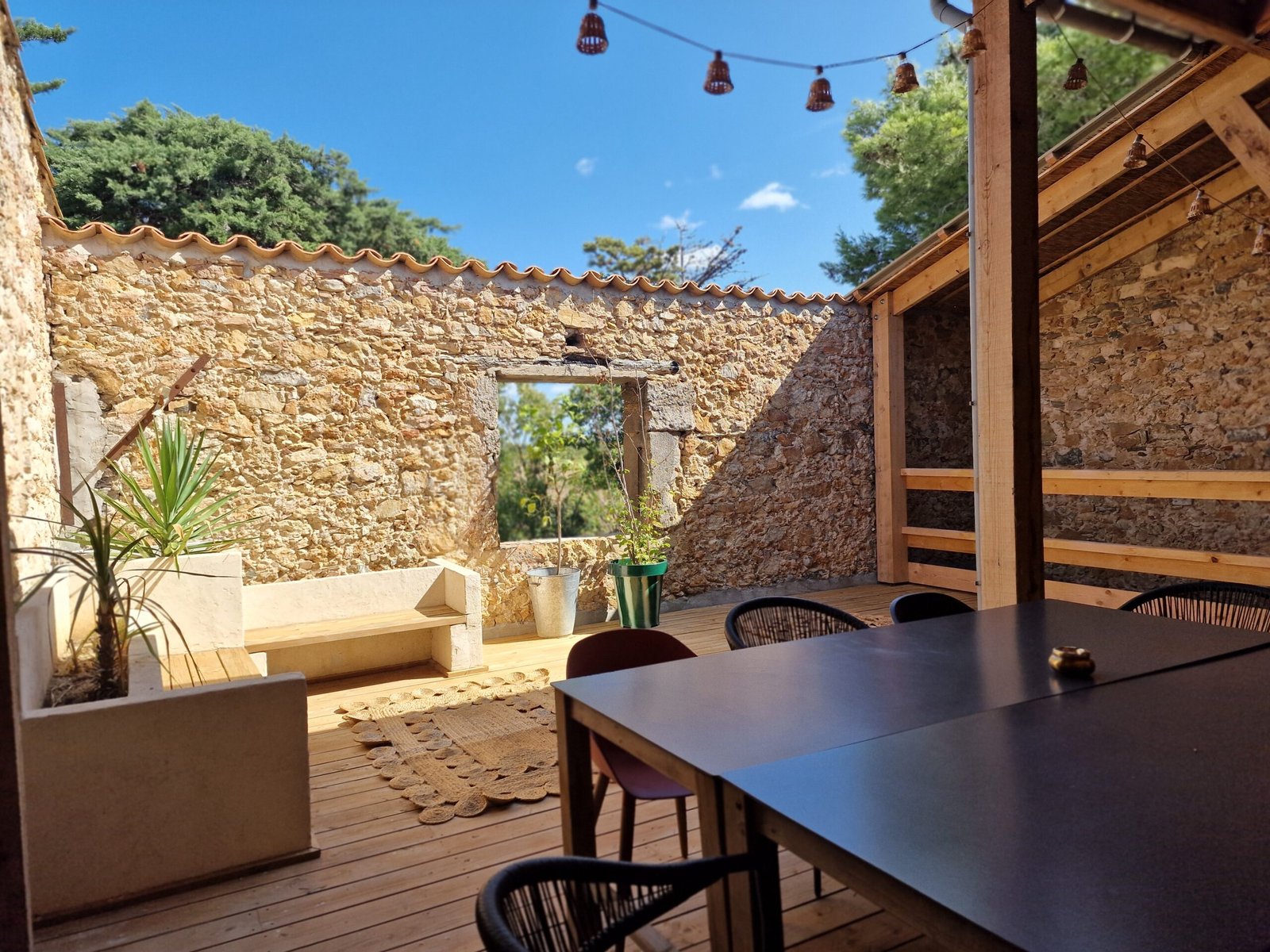 Grande table de repas sur la terrasse du gîte à Narbonne, idéale pour accueillir famille et groupes.