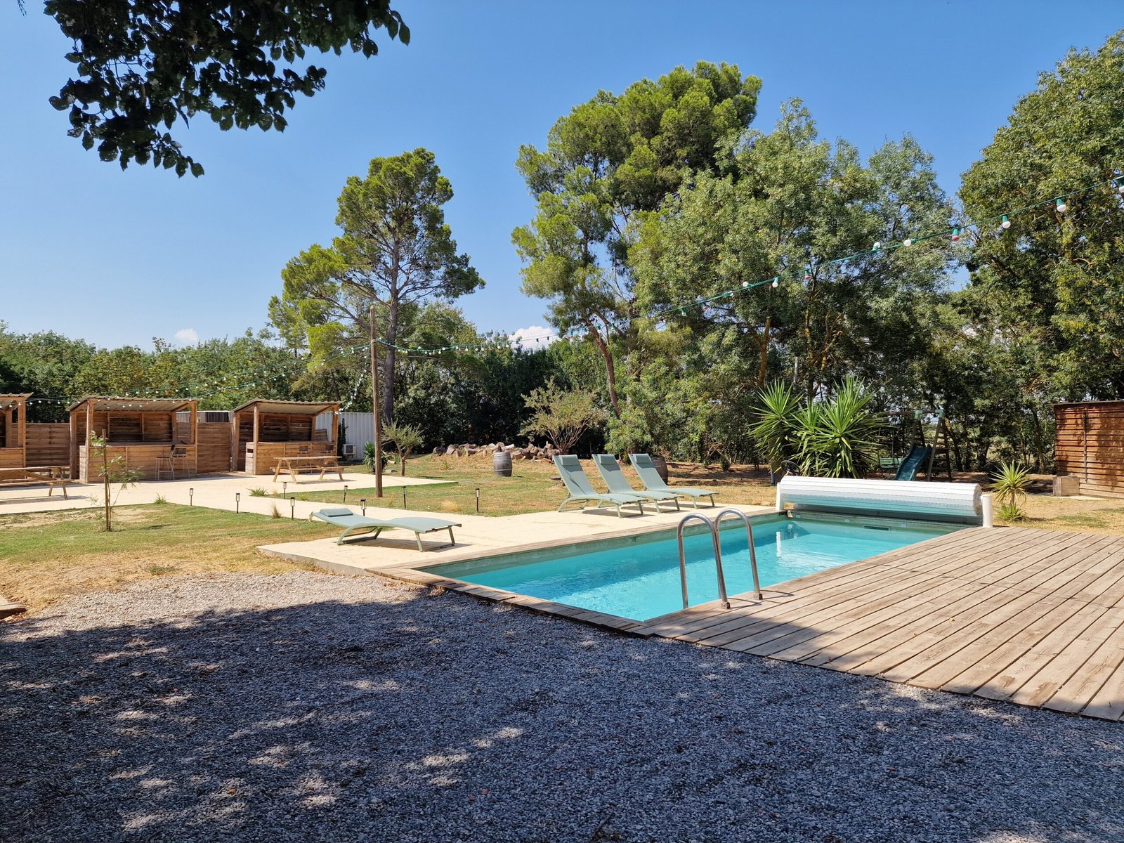 Piscine avec transats au cœur du jardin arboré des gîtes à Narbonne