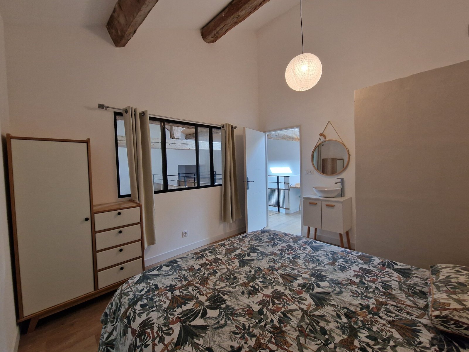 Chambre avec poutres apparentes et rangements dans un hébergement de groupe à Narbonne