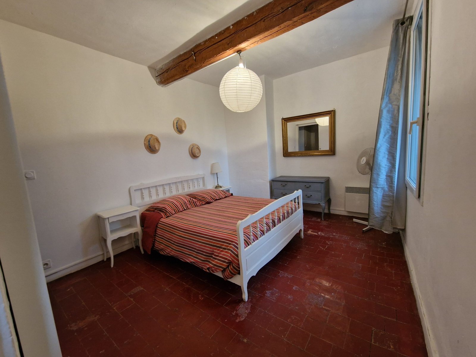 Chambre double lumineuse d’un gîte à Narbonne avec lit deux personnes et poutre apparente.